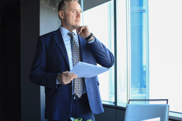 istock Successful mature entrepreneur is studying documents with attentive and concentrated look. 1186686715