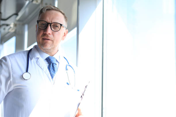 istock Senior chief physician in white robe with stethoscope. 1186686922