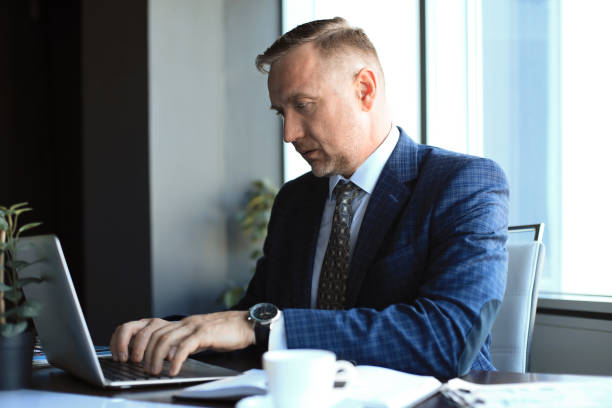 istock Focused mature businessman deep in thought while sitting at a table in modern office. 1186687817