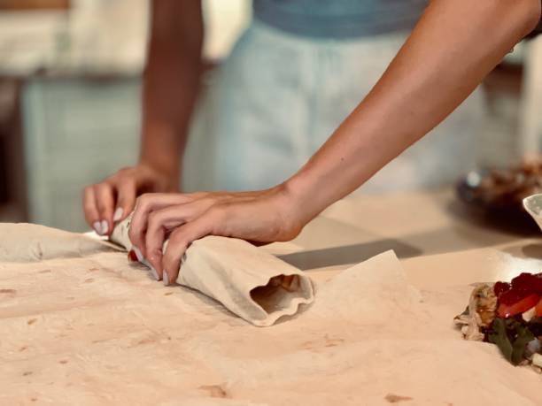 istock girl cooks homemade shawarma 1186688021