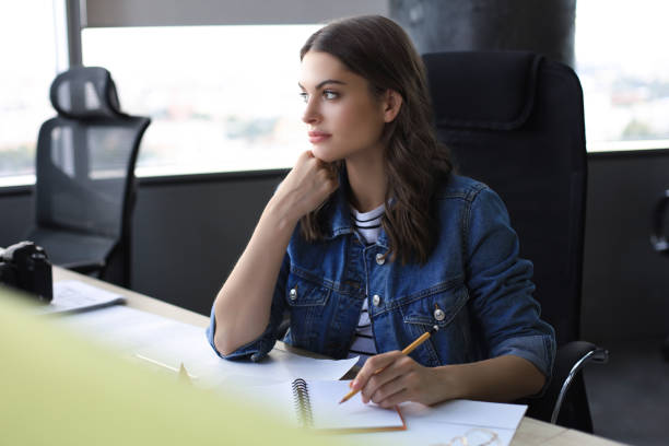 istock Concentrated young woman writing something down while working in the office. 1186688155
