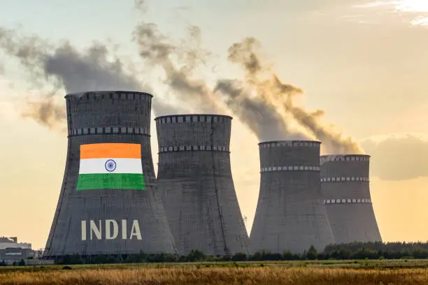 Photo of Nuclear plant chimneys displaying flag of India with according text. Energy pollution accidents in the country concept. Power production and generation from atomic energy.