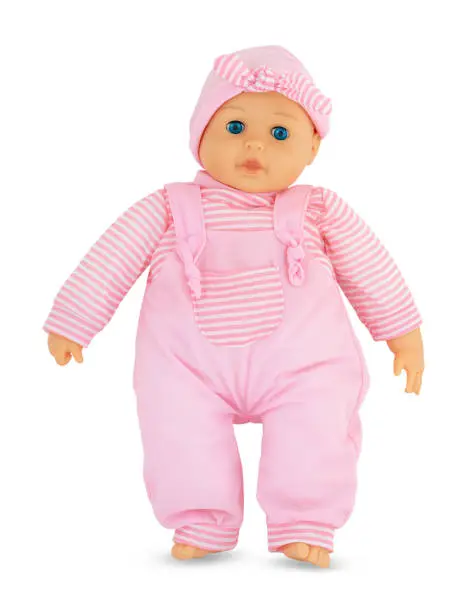 Photo of Plushie doll with blue shiny eyes isolated on white background with shadow. Cute pink rag baby doll on white backdrop. Doll with pinky cap.