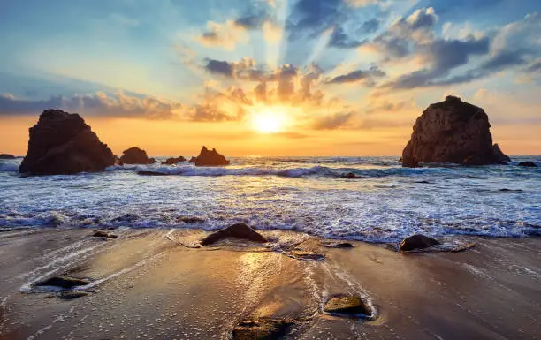 Photo of Sand beach among rocks on evening sunset.