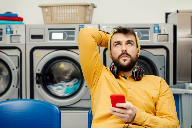 joven lavando su ropa - all laundry detergent audio fotografías e imágenes de stock