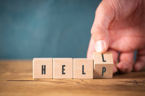 istock hand is flipping a cube turning the word HELL into HELP 1186693167