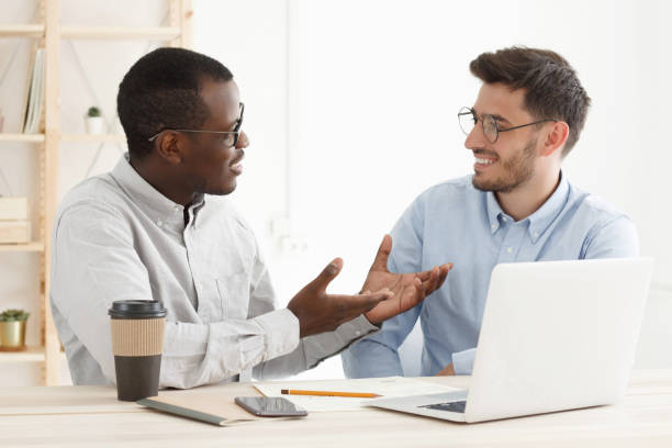 istock Colleagues discussing matters of their common project at office desk 1186694068