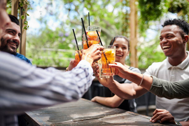 Try best way to start a weekend Shot of a group of young friends toasting with their drinks at a restaurant bar exterior stock pictures, royalty-free photos & images