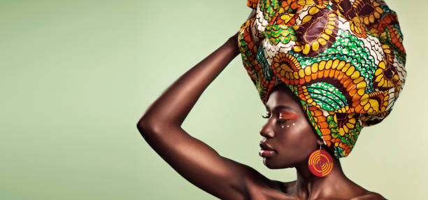 Embrace the history that brought you here Studio shot of a beautiful young woman wearing a traditional African head wrap against a green background turban stock pictures, royalty-free photos & images