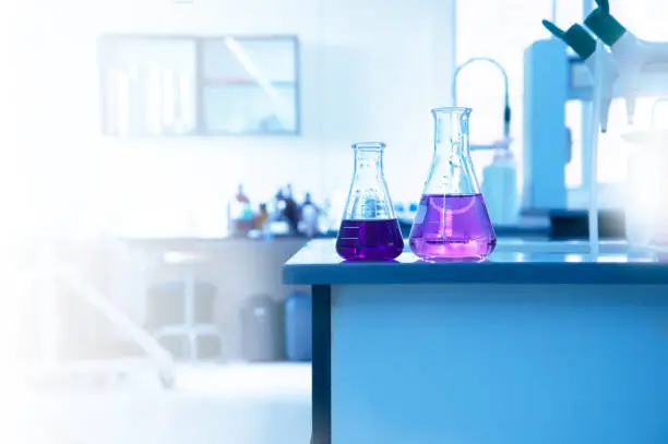 two science glass flask with purple solution on laboratory water sink for chemistry experiment education background