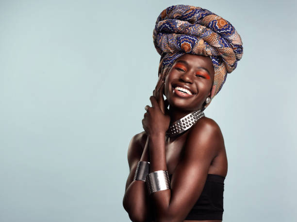 Whatever gets you glowing do that Studio shot of a beautiful young woman wearing a traditional African head wrap against a grey background royal person photos stock pictures, royalty-free photos & images