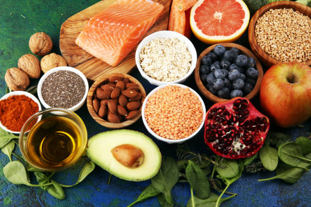istock Healthy food clean eating selection: fish, fruit, vegetable, cereal, leaf vegetable on rustic background 1186700539