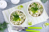 Salad with leek and eggs in portioned white bowls, horizontal, top view