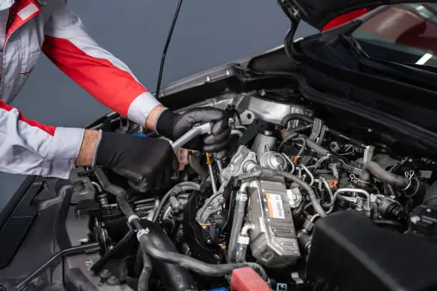 Photo of Auto Mechanic Disassembling the Engine in the Car