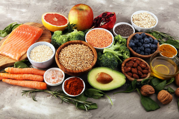 istock Healthy food clean eating selection: fish, fruit, vegetable, cereal, leaf vegetable on rustic background 1186702305