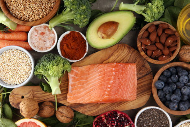 istock Healthy food clean eating selection: fish, fruit, vegetable, cereal, leaf vegetable on rustic background 1186703249