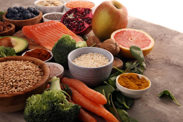 istock Healthy food clean eating selection: fish, fruit, vegetable, cereal, leaf vegetable on rustic background 1186703290