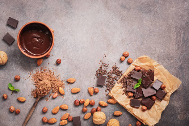istock Melted chocolate, cocoa powder, chocolate slices, nuts and mint on a dark rustic background. Top view, flat lay,copy space 1186703559