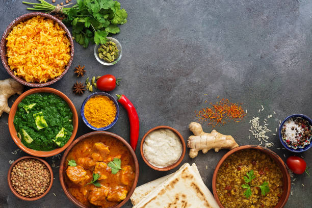 istock Assorted traditional Indian food on a dark background. Corner frame Indian dish Chicken tikka masala, palak paneer, saffron rice, lentil soup, pita bread and spices. Top view, flat lay,copy space. 1186703606