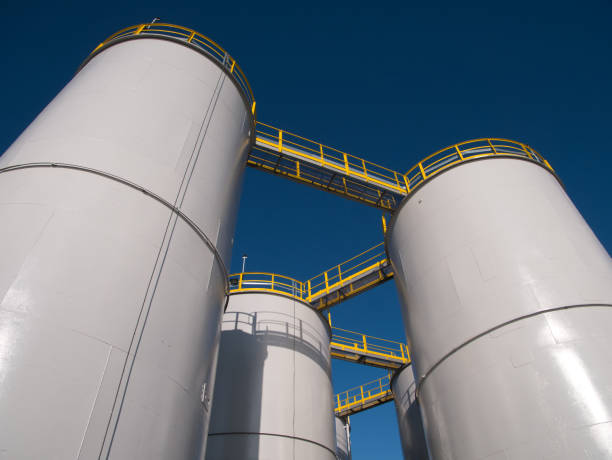 tanques de almacenamiento de aceite / silos contra un cielo azul claro. - storage tank silo chemical factory fotografías e imágenes de stock