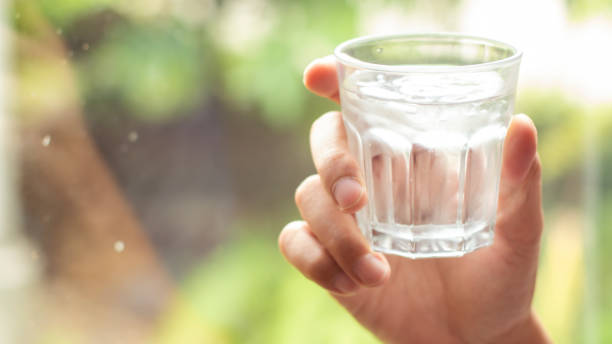 istock hand holds clear water in glass 1186707143