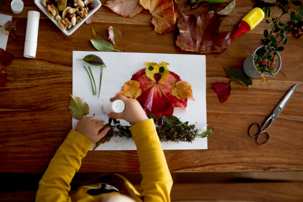 istock Sweet child, toddler boy, applying leaves using glue 1186708000