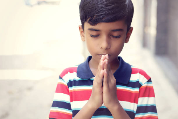 menino pequeno bonito indiano que praying - serene people tranquil scene child god - fotografias e filmes do acervo