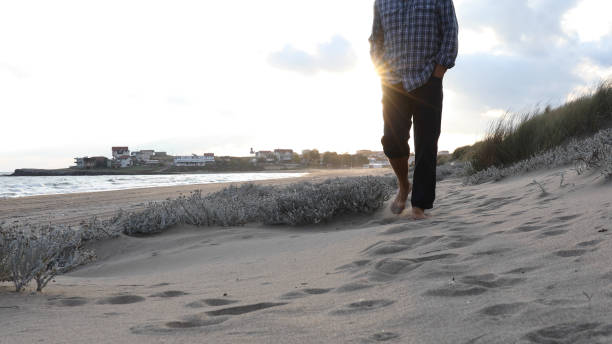 istock Mature man walks along beach at sunrise 1186708664