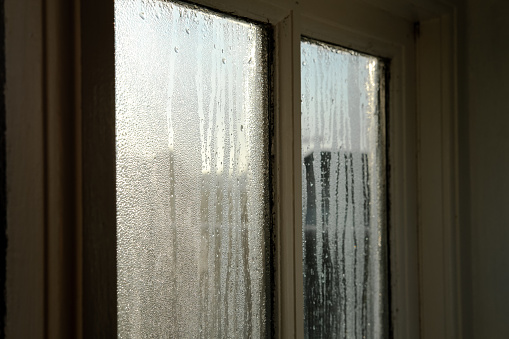 Cold room interior looking out onto water condensation formed on interior windows during early winter.
