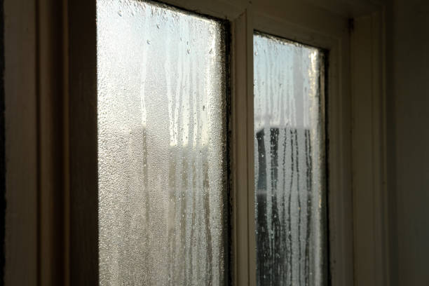 Cold room interior looking out onto water condensation formed on interior windows during early winter. stock photo