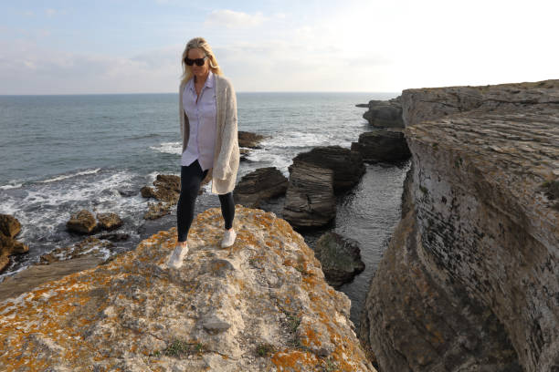 istock Mature woman walks along coastal cliffs at sunrise 1186711821