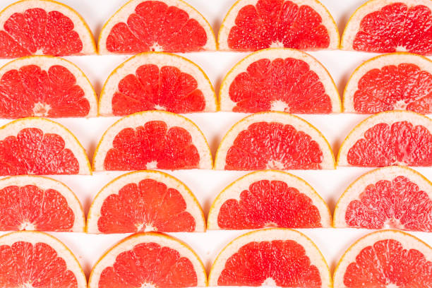 istock Grapefruit red juicy slices background. top view. 1186713960