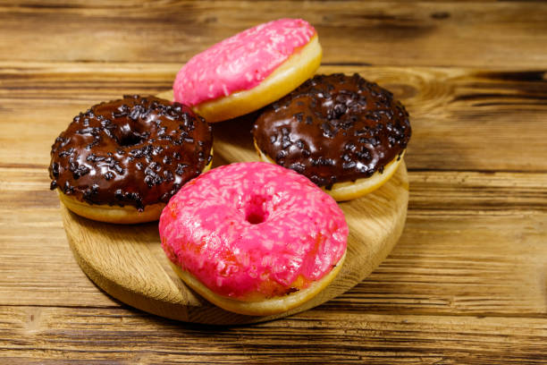 istock Tasty pink and chocolate donuts on a wooden table 1186724219