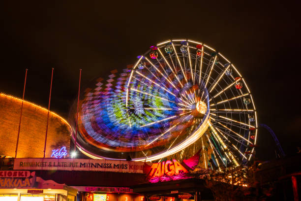 l'evento carnival of light al parco divertimenti linnanmaki. guida la ruota panoramica rinkeli e kehra in movimento, illuminazione notturna, lunga esposizione. - ferris wheel wheel night neon light foto e immagini stock