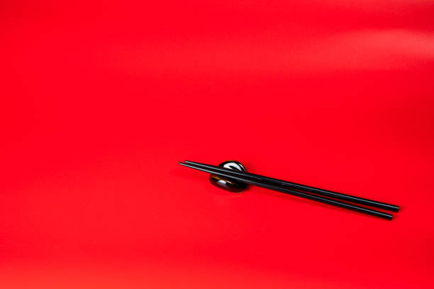 istock Black chopsticks with holder on red background 1186730097