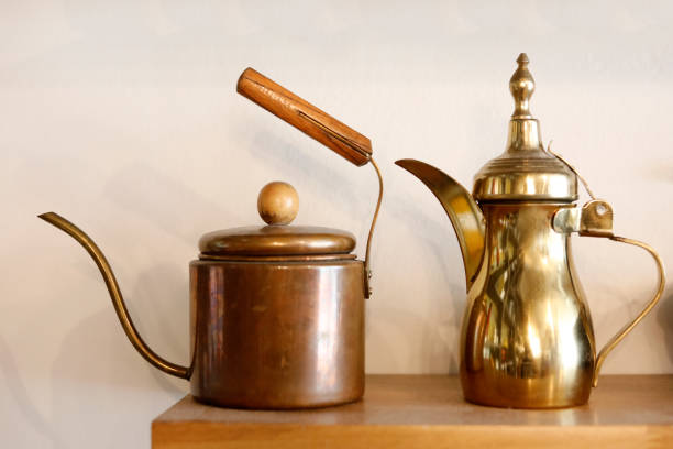 istock view of a pouring brass kettle arab style and copper kettle for dri coffee method , white background, Colour Retro style. with copy space 1186731710