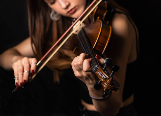 la mano de la mujer en las cuerdas de un violín - musical instrument string music dark old fashioned fotografías e imágenes de stock