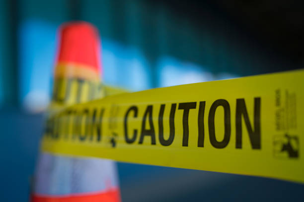 Caution Tape Yellow caution tape attached to traffic cone police tape stock pictures, royalty-free photos & images