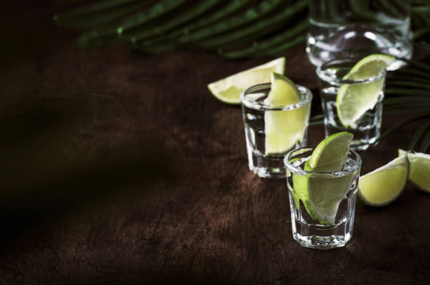 brasilianischer caipirinha oder mojito alkoholischer cocktail mit frischer limette, zuckerrohr wodka cachasa, zuckersirup, limettensaft und zerkleinertem eis in hohem glas auf grauem tisch, bar-werkzeuge, platz für text - tequila slammer stock-fotos und bilder