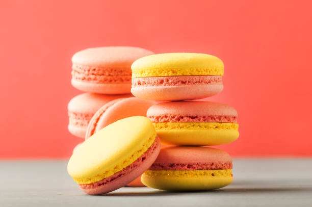 istock Pink yellow macaroons on soft pink background table, place for text, minimalism style 1186733017