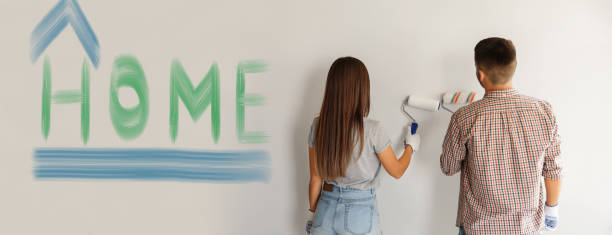 ホーム。ペイントローラーで壁を描く画家のカップル - female house painter home decorator paintbrush ストックフォトと画像
