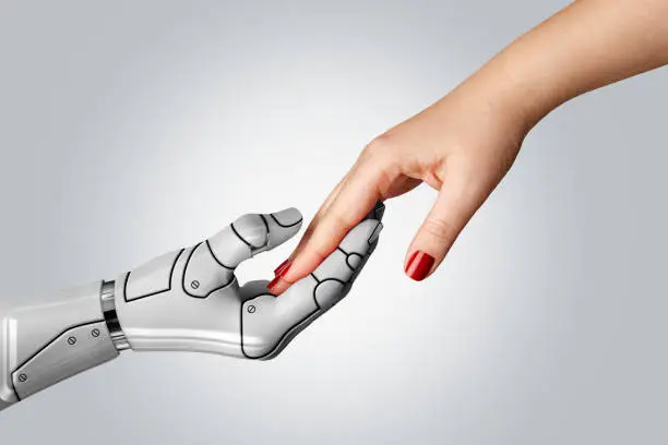 Photo of Robotic cyborg hand holding female human hand