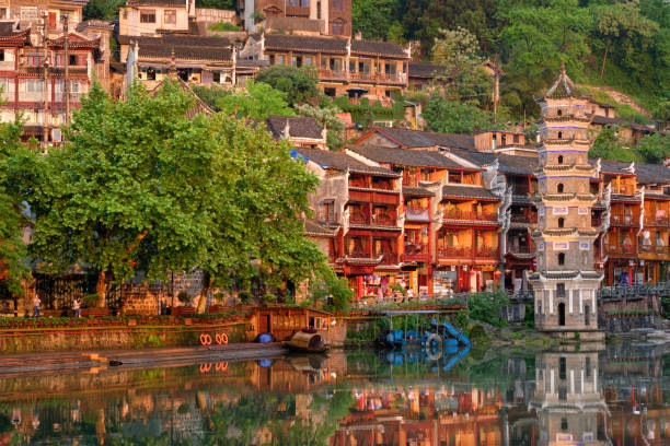 Chinese tourist attraction destination - Feng Huang Ancient Town (Phoenix Ancient Town) on Tuo Jiang River with Wanming Pagoda tower on sunset. Hunan Province, China