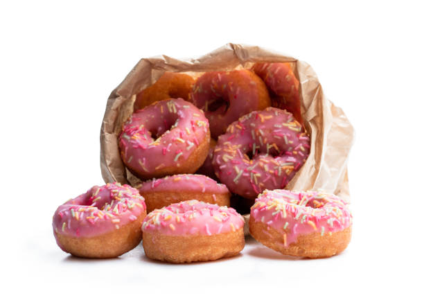istock Mini pink glazed doughnuts in paper bag isolated on white 1186754544