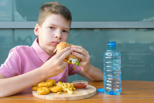istock boy eating fast food from a tray while sitting in a restaurant 1186756578