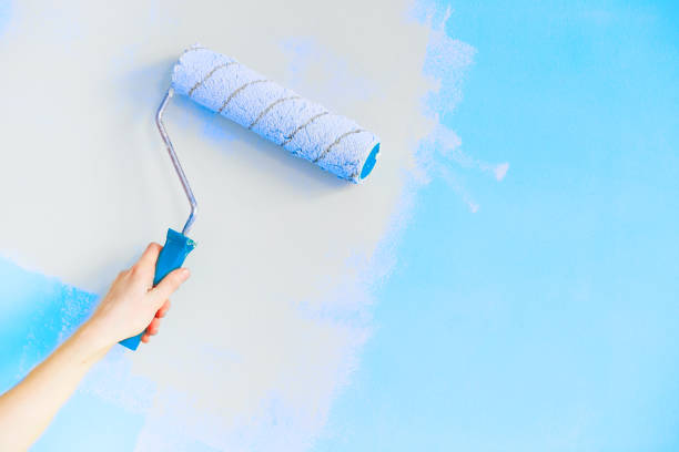istock Close up of Decorator's hand painting wall with roller. copy space 1186759589