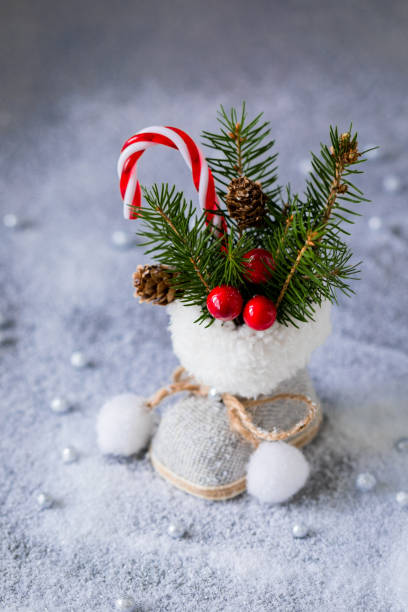 Little Christmas tweed retro boot with fir tree branches, cones and candy canes, postcard concept
