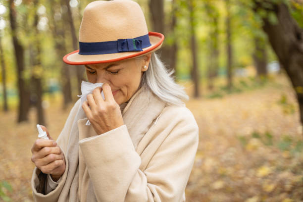 istock Diseased mature lady using her handkerchief outdoors 1186763338