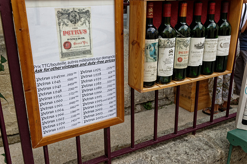 Saint-Emilion France August 2006. Six bottles of very expensive wine in a crate outside a wine merchants for sale. Alongside is the price list.