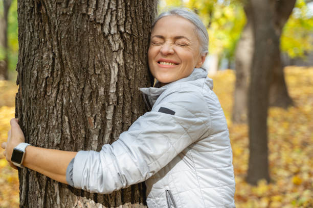 istock Woman with closed eyes standing near a tree 1186763603